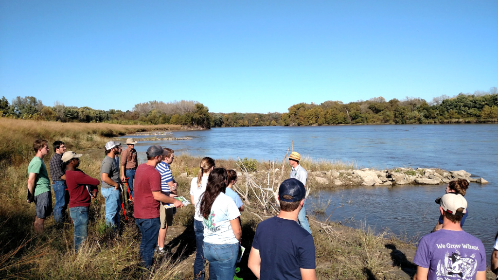 College students tour a riparian buffer strip on the banks of a river