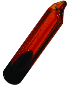 A glass container is shown that is filled with an orange-brown gas and a small amount of dark orange liquid.