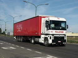 Un camión de plataforma grande que se dirige por una carretera recta.