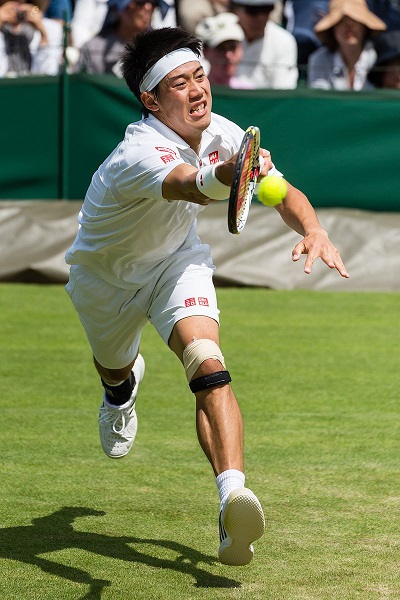 A player in a tennis match lunges for the ball.