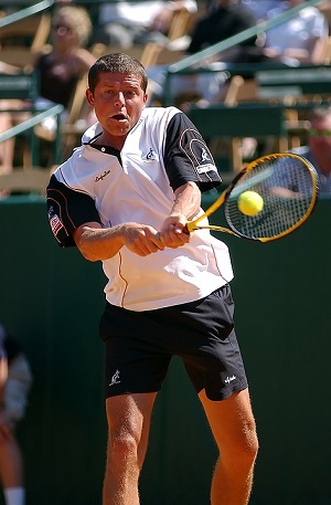 Un jugador de tenis sirve una pelota.
