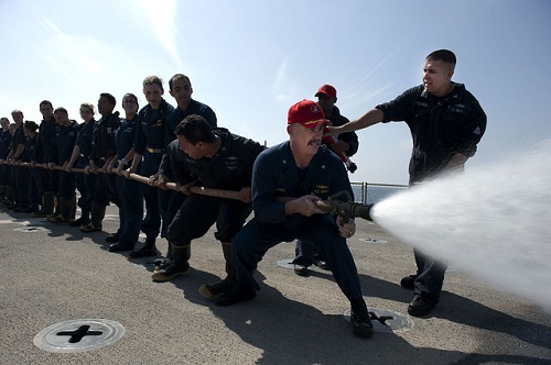A team of firefighters operating a fire hose in a training exercise.