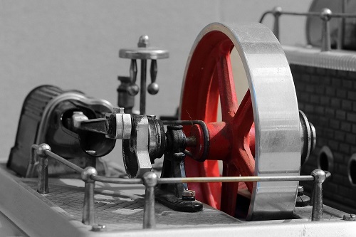 Una imagen de una pequeña máquina de vapor, enfatizando el volante giratorio del motor.