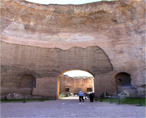 Panoramic view of concrete wall partially covered in mosaic, with small number of people in distance
