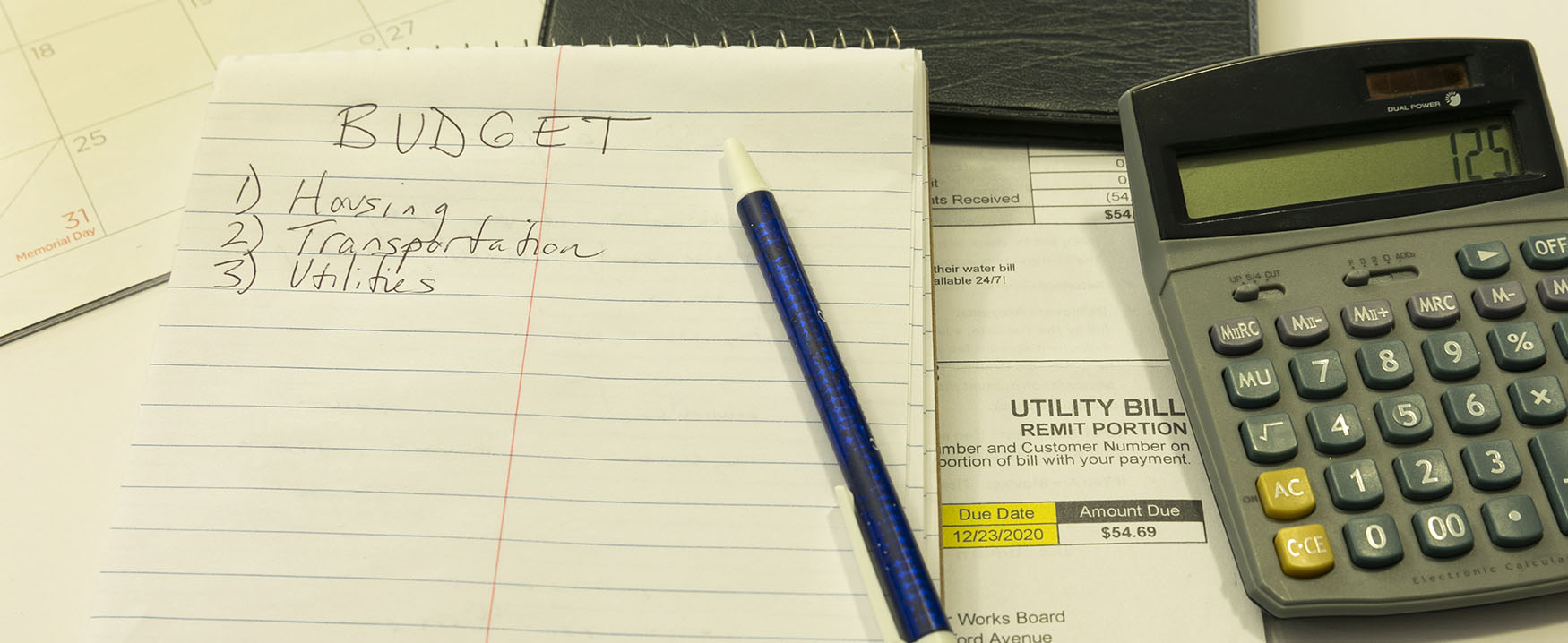 A photo of a notepad and a pen. The notepad says "Budget" across the top, with a numbered list below&hellip;